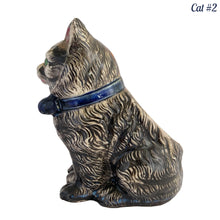 Load image into Gallery viewer, Vintage skillfully hand painted figural tabby cat ceramic planters with intense expressions. These planters have a distinct painting style and date to the 1930s. Features dark charcoal and brown tabby cat with piercing green eyes, pink ears, wearing a blue bow tie. In excellent condition, free from chips/cracks/repairs. Impressed mark on the bottom reads, Made in Japan. Measure 6 1/8 x 4 1/2 x 7 inches