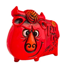 Load image into Gallery viewer, Adorable vintage zodiac sign ceramic coin bank of a grinning bull representing the astrological sign of Taurus. The bull is painted red with embossed features including the word "Taurus," tuft of fur and a flower with the dates April 20-May 20. Crafted by Noritake, Japan, circa 1970s and imported by Giftcraft Canada. A great retro collectible for the Taurus in your life!