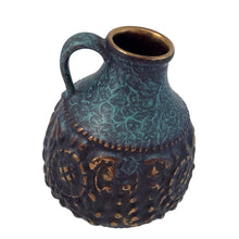 Load image into Gallery viewer, Vintage MCM handled ewer in deep teal, black and the embossed floral pattern in highlighted with gold, on shape 1633-15. Crafted by Jasba, West Germany, 1960s. A wonderful piece of mid-century era art pottery to enhance your home's decor.
In good vintage condition. Minor chip on the floral embossing, no cracks.
Measures 4 1/2 x 6 inches
