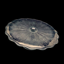 Load image into Gallery viewer, This vintage clear pressed glass round cake stand features a textured pattern radiating from the central rum well and and finished with scalloped edge which is reminiscent of a pressed flower. Maker unknown. A beautiful piece to display cakes and desserts! In excellent condition, free from chips. Unmarked. Measures 12 x 4 1/4 inches