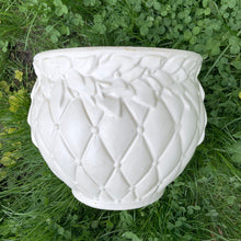 Load image into Gallery viewer, A large vintage "Tierra Cushion" jardiniere or planter pot, glazed in matte white featuring three dimensional flowers and leaves atop a diamond quilted body with ribbon handles. This beauty was produced by McCoy Pottery USA, 1950s. An excellent addition to any art pottery collection!