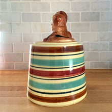 Load image into Gallery viewer, Adorable vintage hand painted ceramic cookie jar topped with a pair of anthropomorphic tiger cubs on a barrel with horizontal stripes in brown, black, turquoise and cranberry on a beige ground. Robinson Ransbottom Pottery Co., 1950s. A excellent example of mid-century era kitsch. Add this darling cookie jar to your kitchen decor or cookie jar collection!
In overall great condition with worn chips on the ears and age-related crazing. Marked R.R.P. Co. Roseville Ohio No - 386.
Measures 7 1/4 x 10 inches