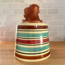 Load image into Gallery viewer, Adorable vintage hand painted ceramic cookie jar topped with a pair of anthropomorphic tiger cubs on a barrel with horizontal stripes in brown, black, turquoise and cranberry on a beige ground. Robinson Ransbottom Pottery Co., 1950s. A excellent example of mid-century era kitsch. Add this darling cookie jar to your kitchen decor or cookie jar collection!
In overall great condition with worn chips on the ears and age-related crazing. Marked R.R.P. Co. Roseville Ohio No - 386.
Measures 7 1/4 x 10 inches