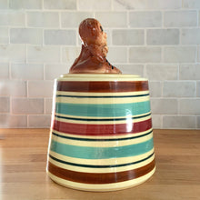 Load image into Gallery viewer, Adorable vintage hand painted ceramic cookie jar topped with a pair of anthropomorphic tiger cubs on a barrel with horizontal stripes in brown, black, turquoise and cranberry on a beige ground. Robinson Ransbottom Pottery Co., 1950s. A excellent example of mid-century era kitsch. Add this darling cookie jar to your kitchen decor or cookie jar collection!
In overall great condition with worn chips on the ears and age-related crazing. Marked R.R.P. Co. Roseville Ohio No - 386.
Measures 7 1/4 x 10 inches