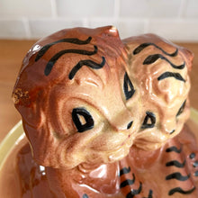 Load image into Gallery viewer, Adorable vintage hand painted ceramic cookie jar topped with a pair of anthropomorphic tiger cubs on a barrel with horizontal stripes in brown, black, turquoise and cranberry on a beige ground. Robinson Ransbottom Pottery Co., 1950s. A excellent example of mid-century era kitsch. Add this darling cookie jar to your kitchen decor or cookie jar collection!
In overall great condition with worn chips on the ears and age-related crazing. Marked R.R.P. Co. Roseville Ohio No - 386.
Measures 7 1/4 x 10 inches