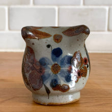 Load image into Gallery viewer, Vintage hand crafted Tonala folk art pottery owl figurine, hand painted and signed by artist Jorge Wilmot, Mexico. This owl has striking eyes, florals in ochre, brown and blue on a gray ground.
In excellent condition, no chips/cracks/repairs.
Measures 2 1/4 x 2 x 2 3/8 inches