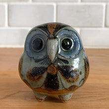 Load image into Gallery viewer, Vintage hand crafted Tonala folk art pottery owl figurine, hand painted and signed by artist Jorge Wilmot, Mexico. This owl has striking eyes, florals in ochre, brown and blue on a gray ground.
In excellent condition, no chips/cracks/repairs.
Measures 2 1/4 x 2 x 2 3/8 inches