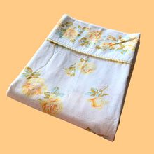Load image into Gallery viewer, Vintage Rose Romance queen size flat poly/cotton white bed sheet featuring roses in shades of yellow, blue and green, trimmed with yellow lace at the band. Crafted by Texmade, Canada, 1973-1977. A beautiful addition to your bedding collection, or repurpose for crafts, quilting or garment making.
In excellent condition, no stains or tears. Appears unused new old stock. Original label present.
Measures 88 x 106 inches | 224 x 270 centimeters.