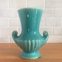 Load image into Gallery viewer, Exceptionally beautiful vintage gloss turquoise art deco vase, featuring a classical grecian urn shape with curled handles. Crafted by McCoy Pottery, early 1940s. This rare vase must for any art pottery collector!
In vintage condition, no cracks/repairs, crazing commensurate with age. Maker's mark on the bottom.
Measures 4 5/8 x 6 inches