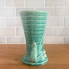 Load image into Gallery viewer, Vintage Art Deco gloss turquoise ring handled trumpet vase with leaves and berries on a ringed body. Crafted by McCoy Pottery, 1940s. This rare piece is must for any McCoy art pottery collector!
In as found vintage condition, no chips/repairs, tight hairline crack and crazing commensurate with age. Unmarked.
Measures 3 1/4 x 5 3/4 inches