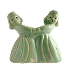 Load image into Gallery viewer, Sweet vintage ceramic planter featuring two dancing Dutch girls, finished in pale green glaze. Crafted by McCoy Pottery, USA, circa 1930s. Perfect to use a decor piece, a tiny houseplant or repurpose to hold make-up brushes. Makes an excellent gift! In excellent condition, free from chips/cracks. Measures 4 3/4 x 2 3/8 x 4 1/2 inches