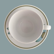 Load image into Gallery viewer, Vintage Progression Up-Sa Daisy high quality stoneware teacup and saucer features an aque blue daisy with moss green and black centres and moss green band at the rim. Crafted by Noritake, Japan, 1966 - 1979. This darling flower pot shaped teacup and saucer will add tons of vintage charm to your table! In excellent condition and appear unused. Free from chips/cracks/repairs. Colours are vibrant. Teacup measures 3 3/8 x 3 inches Saucer measures 6 inches Capacity 8 ounces