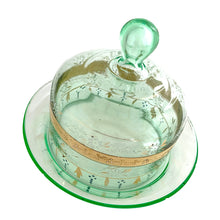 Load image into Gallery viewer, Antique Victorian era hand blown green uranium glass covered butter dish featuring gold, white and blue enamel decoration. Glows beautifully under black light. Crafted by Fenton Art Glass, USA, early 20th century. A stunning piece to add to your glass collection.
In as found vintage condition with wear to the enamel and chips to the dish rim and roughess to the lid rim.
Measures 7 1/8 x 7 1/8 x 5 1/2 inches
