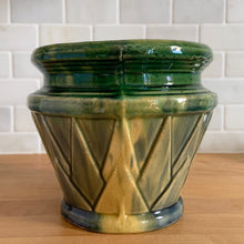 Load image into Gallery viewer, Rare antique Art Deco blended gloss glazed "V" jardiniere planter pot, features an overlapping pointed leaf or sunburst pattern on green, blue and yellow blend of glazes. Crafted by McCoy Pottery, USA, 1920s. This rare vintage planter is highly sought after and a must-have for any McCoy collector or container garden lover!
In excellent vintage condition, no chips/cracks/repairs, age-related crazing, manufacturer's glaze pops, minor hard water marks. Unmarked.
Measures 7 1/4 x 6 1/2 inches