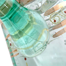 Load image into Gallery viewer, Antique Victorian era green uranium glass pitcher featuring gold, white and red enamel decoration with ruffle crimped rim and an applied handle. Glows beautifully under black light. Crafted by Fenton Art Glass, USA, early 20th century. A stunning piece to add to your glass collection.
In as found vintage condition with wear to the enamel. There is a stringer in the handle and a chip to the base of the handle itself.
Measures 5 3/4 x 8 x 10 inches