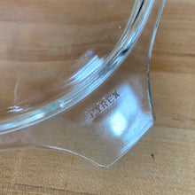 Load image into Gallery viewer, Close-up of embossed PYREX brand name on Cinderella tab handle of vintage clear glass 474-C casserole lid