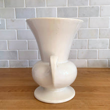 Load image into Gallery viewer, Vintage mid-century gloss white trumpet vase with curled handles. Crafted by McCoy Pottery, late 1950s. This lovely vase is must for any art pottery collector!
In as found vintage condition, chip to the exterior rim, no cracks/repairs, crazing commensurate with age. Maker's mark on the bottom.
Measures 6 1/4 x 5 7/8 x 8 inches
