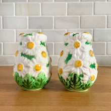 Load image into Gallery viewer, Pretty vintage mid-century hand painted "Daisytime" ceramic salt and pepper shakers featuring an overall pattern of raised white daisy flowers with yellow centres and green leaves. Crafted by PY, Japan, circa 1950s. A pretty addition to any tablescape! In vintage condition, minor flea bites, no cracks/repairs. Original corks are inside with new corks provided. Bottoms marked "Daisytime PY 22648" Measures 2 1/2 x 3 5/8 inches