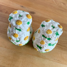 Load image into Gallery viewer, Pretty vintage mid-century hand painted "Daisytime" ceramic salt and pepper shakers featuring an overall pattern of raised white daisy flowers with yellow centres and green leaves. Crafted by PY, Japan, circa 1950s. A pretty addition to any tablescape! In vintage condition, minor flea bites, no cracks/repairs. Original corks are inside with new corks provided. Bottoms marked "Daisytime PY 22648" Measures 2 1/2 x 3 5/8 inches