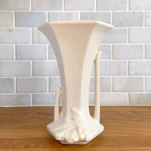 Load image into Gallery viewer, Front view of matte white hexagonal Art Deco trumpet vase with asymmetric cutout handles and embossed leaves, Nelson McCoy Pottery, USA 1940s.