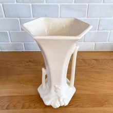 Load image into Gallery viewer, Elevated angled view of the matte white vase showing the flared hexagonal silhouette and embossed leaf motif at the base. Nelson McCoy Pottery, USA 1940s.