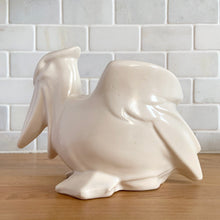 Load image into Gallery viewer, Vintage mid-century era matte white Pelican pattern planter. Crafted by Nelson McCoy Pottery, 1948. Perfect as a succulent planter or to hold baby accessories as part of your nursery decor! This rare piece is must for any art pottery collector.
In excellent vintage condition, no chips/cracks/repairs, age-related crazing and interior staining. Manufacturer's glaze pops. Maker's mark.
Measures 7 3/4 x 4 1/4 x 5 1/2 inches