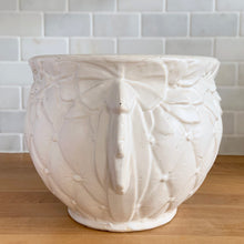 Load image into Gallery viewer, Vintage matte white Tierra Cushion jardiniere planter pot, features an overlapping floral leaf pattern around the top rim, a diamond quilted body and ribbon handles. Crafted by McCoy Pottery, USA, 1950s. A must-have for any McCoy collector or container gardener!
In excellent vintage condition, no chips/cracks/repairs, age-related crazing, manufacturer's glaze pops. Maker's mark.
Measures 9 x 7 3/8 inches