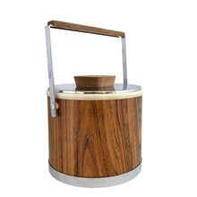 Load image into Gallery viewer, Vintage ice bucket featuring a chrome base, wood grained bucket, topped with a chrome and wood handle and lid; the interior is cream coloured plastic. Crafted by Kromex, USA, circa 1960s. A fabulous example of mid-century design and style!
In used excellent used condition. The handle and knob are in excellent condition. Marked on the bottom with Kromex and Made in the USA.
Measures 8 1/8 x 7 1/4 inches