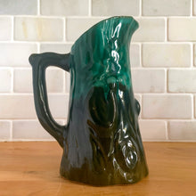Load image into Gallery viewer, This gorgeous Evangeline pitcher features a stunning design of raised mushrooms and knots around a tree trunk. This sweet pitcher makes for a beautiful statement piece or a functional pitcher for your home. In excellent condition, free from chips/cracks. Measures 3 3/4 x 6 3/8 inches