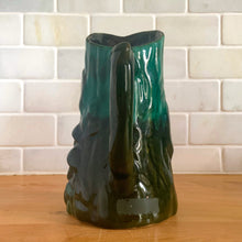Load image into Gallery viewer, This gorgeous Evangeline pitcher features a stunning design of raised mushrooms and knots around a tree trunk. This sweet pitcher makes for a beautiful statement piece or a functional pitcher for your home. In excellent condition, free from chips/cracks. Measures 3 3/4 x 6 3/8 inches