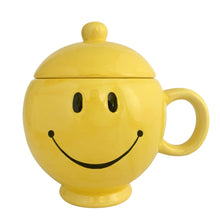 Load image into Gallery viewer, Bring on the happy with this vintage bright yellow smiley face lidded mug. Novelty gift crafted by Teleflora Gift, China, 1970s. In excellent condition, no chips/cracks/repairs. Minor manufacturers defect at the mug rim, see photos. Measures 4 1/4 x 6 inches. Capacity 20 ounces