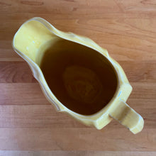 Load image into Gallery viewer, Charming vintage sunny yellow tulip pitcher. Crafted by McCoy Pottery, 1940s. This collectible pitcher is the perfect vessels to hold a charming bouquet of spring flowers or a lovely gift for an art pottery collector.
In as found vintage condition, chip to the rim and handle, tight horizontal hairline crack on handle, age-related crazing, manufacturer's glaze pops. Maker's mark.
Measures 8 1/4 x 3 1/2 x 6 inches