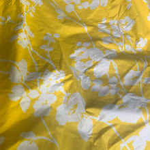 Load image into Gallery viewer, A stunning crisp yellow and white floral printed cotton fabric from The Flower Show Collection in the "Spring Rambler" pattern of white florals against vibrant yellow creating a silhouette effect. The yardage is hemmed at each end. Repurpose this gorgeous textile for sewing and craft projects Free from stains/tears. Marked along the selvedge "Spring Rambler from the Flower Show Collection © by Greeff. Printed in England for Warner & Sons Limited. Measures 100 x 52 inches (8.33 yards)