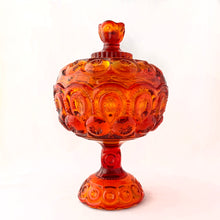 Load image into Gallery viewer, Gorgeous vintage pressed glass amberina Moon and Stars pedestal lidded compote or candy dish. Crafted by the LE Smith Glass Company between 1940s – 2004. This beauty glows brilliantly under black light. This classic candy dish will make a fabulous addition to your glass collection.
In as found vintage condition. The compote is in excellent condition, no chips. The lid has chipping at the rim in several places, see photos.
Measures 6 3/8 x 10 inches