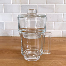 Load image into Gallery viewer, Rare vintage modernist clear glass stackable creamer and covered sugar. Designed by Joe Colombo for Arno, Italy, 1960s. Each piece has a sleek geometric design with a silhouette that makes the contents in this pressed glass appear suspended above the table surface.
Both the creamer and sugar are in excellent condition, no chips or cracks and minimal wear.
Sugar bowl measures 3 3/8 x 3 3/8 x 3 3/8 inches
Creamer measures 4 x 3 3/8 x 3 1/4 inches