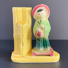 Load image into Gallery viewer, A vintage ceramic vase of planter in the Chinoiserie style features a green and red Asian figure with a yellow bamboo vase on a podium, shape 702. Crafted by Shawnee Pottery USA. Perfect as a bud vase or to a decor accent.
In good vintage condition, no cracks. Small glaze miss on the front of the podium.
Measures 5 x 2 1/2 x 5 1/2 inches