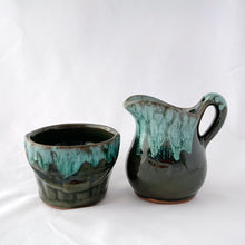 Load image into Gallery viewer, A vintage green drip glaze creamer and open sugar bowl set. The sugar bowl is in the shape of a old fashioned bucket...super cool! The contrast of the colours is outstanding. Produced by McMaster Canada, circa 1970. Excellent condition, no chips or cracks. Creamer measures 4 1/4 x 4 1/4 inches Sugar measures 3 1/2 x 2 1/2 inches