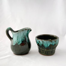 Load image into Gallery viewer, A vintage green drip glaze creamer and open sugar bowl set. The sugar bowl is in the shape of a old fashioned bucket...super cool! The contrast of the colours is outstanding. Produced by McMaster Canada, circa 1970. Excellent condition, no chips or cracks. Creamer measures 4 1/4 x 4 1/4 inches Sugar measures 3 1/2 x 2 1/2 inches