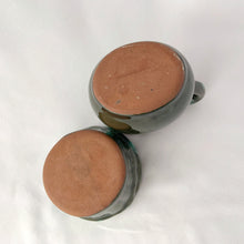Load image into Gallery viewer, A vintage green drip glaze creamer and open sugar bowl set. The sugar bowl is in the shape of a old fashioned bucket...super cool! The contrast of the colours is outstanding. Produced by McMaster Canada, circa 1970. Excellent condition, no chips or cracks. Creamer measures 4 1/4 x 4 1/4 inches Sugar measures 3 1/2 x 2 1/2 inches