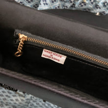 Load image into Gallery viewer, Gorgeous vintage mid-century era handmade black satin evening bag, adorned in a floral pattern of black glass beads with snap closure. This versatile bag has detachable strap allowing it be worn as a purse or clutch. The interior is lined with black satin and has a large zippered pocket. Crafted by Contessa Francesca, Hong Kong, 1950s. This generous sized bag accommodates a cell phone and other necessities for your evening affair.
Measures 8 1/2 x 1 1/4 x 4 inches (without handle), strap handle 14 inches
