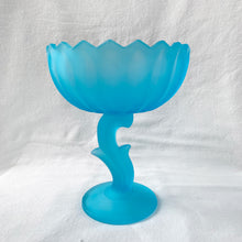 Load image into Gallery viewer, Vintage satin blue "Lotus Blossom" pedestal compote featuring a feminine botanical stem and bowl pedestal with a sawtooth edge. Crafted by Indiana Glass, USA, circa 1970s. Perfect to serve snacks/fruit. Easily repurpose as a catchall or vanity/dresser to hold cotton balls, bath bombs or trinkets. This elegant statement piece will add drama to any home decor style! In excellent condition, free from chips. Measures 6 1/8 x 7 1/2 inches