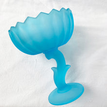 Load image into Gallery viewer, Vintage satin blue "Lotus Blossom" pedestal compote featuring a feminine botanical stem and bowl pedestal with a sawtooth edge. Crafted by Indiana Glass, USA, circa 1970s. Perfect to serve snacks/fruit. Easily repurpose as a catchall or vanity/dresser to hold cotton balls, bath bombs or trinkets. This elegant statement piece will add drama to any home decor style! In excellent condition, free from chips. Measures 6 1/8 x 7 1/2 inches