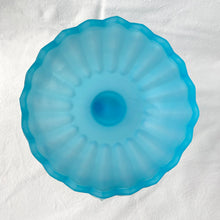 Load image into Gallery viewer, Vintage satin blue "Lotus Blossom" pedestal compote featuring a feminine botanical stem and bowl pedestal with a sawtooth edge. Crafted by Indiana Glass, USA, circa 1970s. Perfect to serve snacks/fruit. Easily repurpose as a catchall or vanity/dresser to hold cotton balls, bath bombs or trinkets. This elegant statement piece will add drama to any home decor style! In excellent condition, free from chips. Measures 6 1/8 x 7 1/2 inches