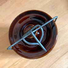Load image into Gallery viewer, Vintage dark brown glazed pottery storage crock with wire bail closure. Maker unknown. Made in the USA and marked 1059¢ on the bottom. Take the lid off and repurpose as a pencil/pen/make-up brush holder, planter change holder, or use as a decor piece. In excellent condition, free from chips/cracks/repairs. Measures 3-1/4" x 5"
