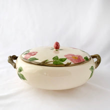 Load image into Gallery viewer, Vintage Desert Rose covered vegetable dish. The cream coloured dish features hand painted pink and green florals with brown branch handles and a pink rose finial on the lid. Crafted by Franciscan, England, 1985 - 2003. Highly collectible and beautiful!
In excellent vintage condition, no chips/cracks/repairs. One handle has tiny spot of glaze loss, see photos. Maker's marks.
Measures 6 3/4 x 4 1/4 inches