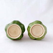 Load image into Gallery viewer, Sweet pair of vintage hand painted "Desert Rose" salt and pepper shakers. Pink and green figural roses. Produced by Franciscan, England, between 1985 - 2003. In great vintage condition. The salt shaker has a minor chip on the inside rim of the bottom lip which can't be seen from the outside (see photos). Each shaker has the original rubber stopper. Measures 2-12" tall.