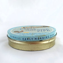 Load image into Gallery viewer, Vintage Early Morning Pipe tobacco tin with original interior wrap and tariff sticker. The lid has a great graphic of a sunrise and a rooster crowing on a pale blue background. Produced by Alfred Dunhill in England. In good vintage condition with minor wear. Measures 4 x 1 inches