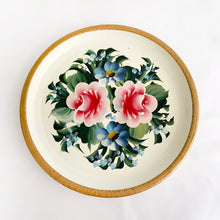 Load image into Gallery viewer, It's such a wonderful feeling when we stumble on such a lovely hand painted piece like this vintage metal tray. The florals are artfully painted in shades of pink and blue on a cream background with a gold rim. Great to use on a vanity, dresser or as wall art. The painting is vibrant and in great vintage condition with very little wear. Measures 12" in diameter
