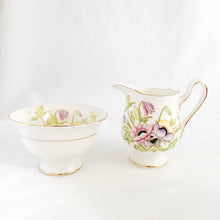 Load image into Gallery viewer, RARE vintage Gloria bone china creamer pitcher and open sugar, hand painted in shades pink, purple and yellow flowers with green and gold gilt accents. Crafted by Royal Albert, England, circa 1940. A beautiful addition to your tableware!
In excellent condition, no chips/cracks/repairs.
Creamer measures 4 x 3 1/2 inches
Sugar measures 3 7/8 x 2 1/4 inches