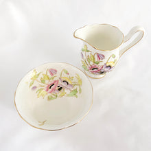 Load image into Gallery viewer, RARE vintage Gloria bone china creamer pitcher and open sugar, hand painted in shades pink, purple and yellow flowers with green and gold gilt accents. Crafted by Royal Albert, England, circa 1940. A beautiful addition to your tableware!
In excellent condition, no chips/cracks/repairs.
Creamer measures 4 x 3 1/2 inches
Sugar measures 3 7/8 x 2 1/4 inches